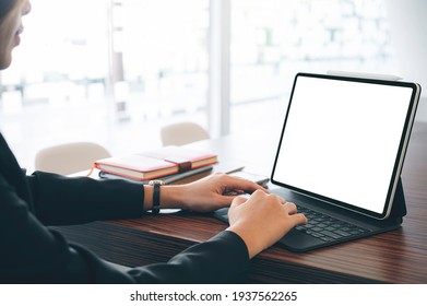 Cropped Shot Of Woman Hands Working On Tablet With Keyboard While Sitting At The Table, Blank Screen For Graphic Desing.