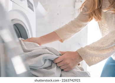 Cropped shot of woman load the washing machine doing laundry at home, cleaning housework concept - Powered by Shutterstock