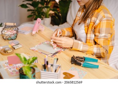 Cropped shot of women making homemade scrapbooking album from paper. DIY, hobby concept, gift idea, decor with handcraft attributes, home production, the process of creation, creativity.