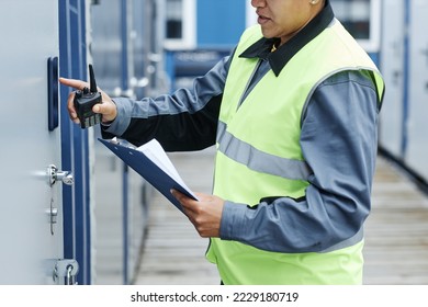 Cropped shot of worker entering key code on storage unit and holding clipboard - Powered by Shutterstock