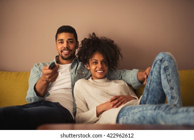 Cropped shot of a young african american couple watching television at home.
