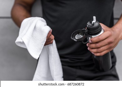 Cropped Shot Of Young African American Sportsman Holding Sports Bottle And Towel