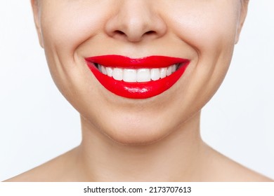 Cropped shot of young caucasian smiling woman with the perfect even teeth isolated on a white background. Beautiful Hollywood smile with red lipstick. Teeth whitening. Oral hygiene, dental health care