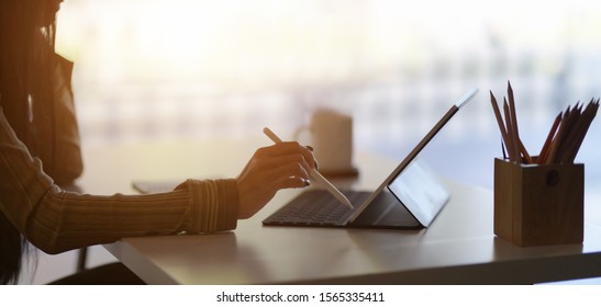 Cropped shot of young female designer drafting her project with digital tablet in modern office room  - Powered by Shutterstock