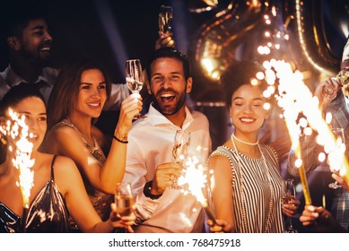 Cropped shot of young friends holding sparklers at a party - Shutterstock ID 768475918