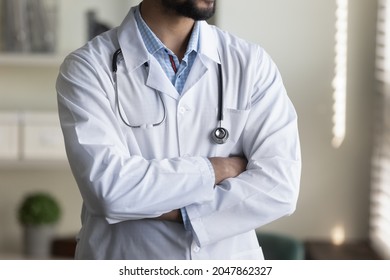 Cropped shot of young male doctor in white coat and stethoscope. Confident general practitioner, medical specialist, physician, counselor standing with folded arms. Medic care profession