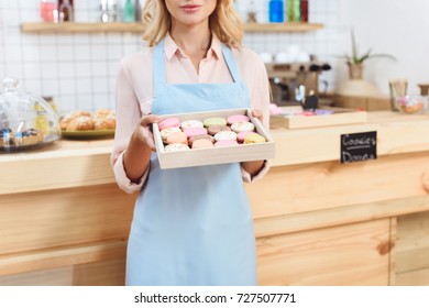 cropped shot of young waitress holding tasty cookies in box - Powered by Shutterstock