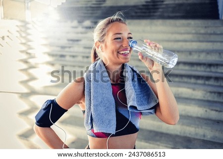 Cropped shot of a young woman enjoying a bottle of water while workingout during the day. Sporty young woman drinking water while exercising outdoors