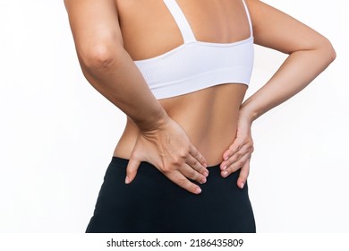 Cropped Shot Of A Young Woman Holding Her Lower Back With Her Hands Isolated On A White Background. Back Pain. Sciatica, Osteochondrosis, Gallstone Disease, Pancreatitis. Sports Injury