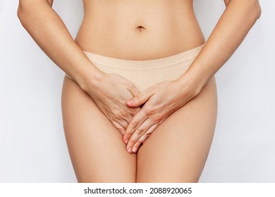 Cropped shot of a young woman in underwear holding her crotch with her hands, suffering from cystitis isolated on white background. Gynecological problems, genital tract infections. Healthcare concept
