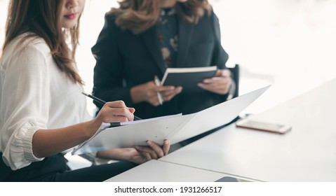 Cropped Shote Of Young Female Business People Woking On Paperwork Together In Office.