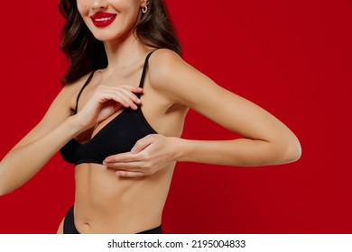 Cropped Side View Young Sexy Woman With Perfect Fit Body In Black Underwear Put Hand On Chest Breast Cancer Early Diagnostic Therapy Treatment Isolated On Plain Red Background. Female Beauty Concept.