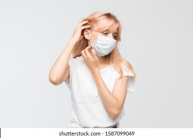 Cropped Studio Portrait Of Woman In White T-shirt With Medical Mask Who Scratching Itchy Throat. Irritation, Sensitive Dry Skin, Allergy Symptoms, Dermatitis, Insect Bites. Healthcare Concept.