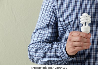 Cropped Studio Shot Of Man Holding Energy Saving Lightbulb