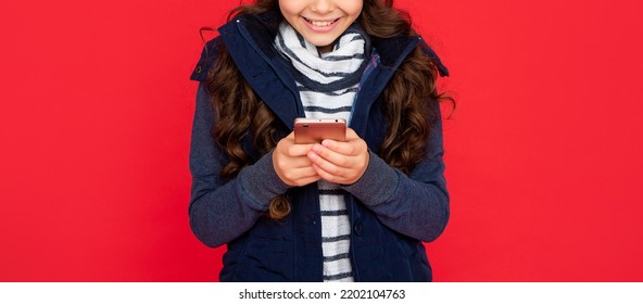 Cropped Teen Girl In Down Vest Texting On Smartphone. Portrait Of Child Blogging With Phone.