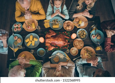 Cropped top above high angle view of nice big full peaceful idyllic family praying before eating brunch meal dishes served table grateful for good harvest blessing tradition in house restaurant - Powered by Shutterstock