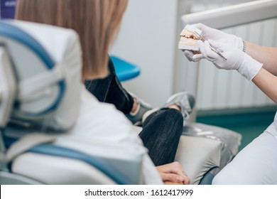 cropped unrecognizable dentist and patient in dental office, doctor show prosthesis to patient. Health and medicine concept - Shutterstock ID 1612417999