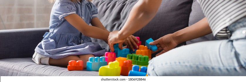 Cropped View Of African American Babysitter And Child Playing With Colorful Building Blocks On Sofa, Horizontal Image