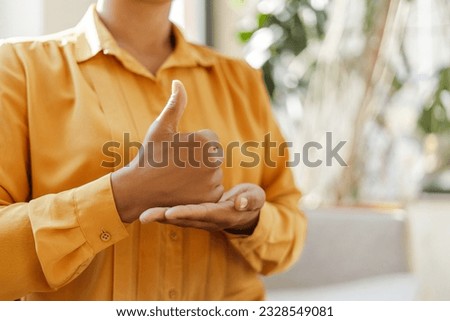 Cropped view of the african american deaf sign language teacher communicating by hands gestures at light colours cafeteria. Deafness concept