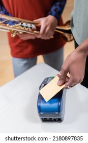 Cropped View Of African American Man Paying With Credit Card Near Girlfriend With Trumpet In Music Store