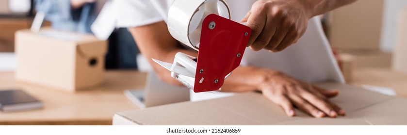 Cropped View Of African American Seller Holding Adhesive Tape Near Carton Box In Online Web Store, Banner