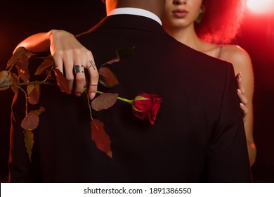 Cropped View Of African American Woman Holding Rose And Embracing Man In Formal Wear On Black