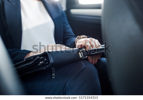 cropped view of ambassador holding briefcase while\
sitting in car 