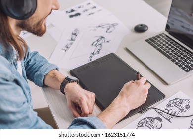 Cropped View Of Animator In Headphones Using Digital Tablet