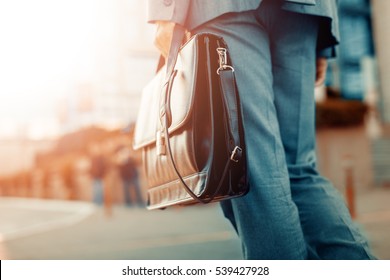 Cropped view of businessman holding a briefcase outdoors