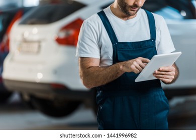 cropped view of car mechanic using digital tablet in car service  - Powered by Shutterstock