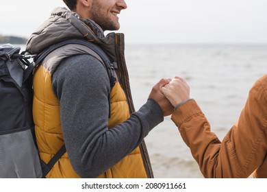 Cropped View Of Couple Holding Hands While Having Walk Near Lake