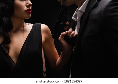 Cropped View Of Dangerous Woman Holding Gun Near Man In Suit Isolated On Black