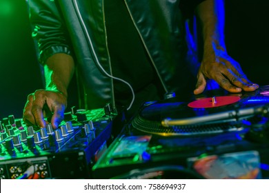 cropped view of DJ with sound mixer and vinyl in nightclub 