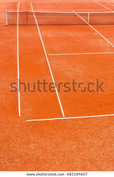 Cropped view of\
empty, red clay, tennis\
court