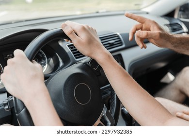 cropped view of father pointing away with finger while teenage son driving car - Powered by Shutterstock