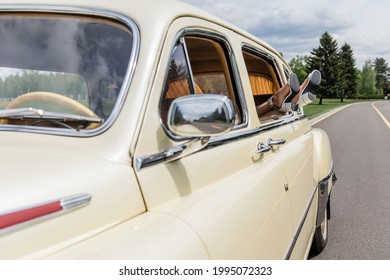Cropped View Of Female Legs In Window Of Vintage Car On Road