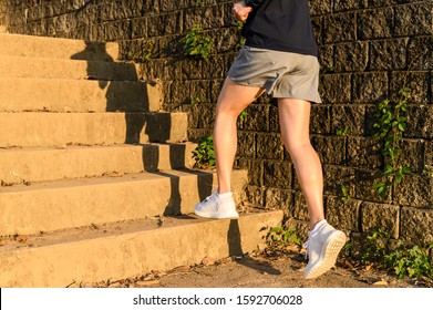 Cropped View Of Fitness Runner Woman Training Herself By Running Up Steps On Staircase In Urban Street. Uphill Running Can Improve Average Running Speed And Your Step Length Greater Benefit.