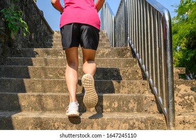 Cropped View Of Fitness Runner Woman Training Herself By Running Up Steps On Staircase In Urban Street. Uphill Running Can Improve Average Running Speed And Your Step Length Greater Benefit.