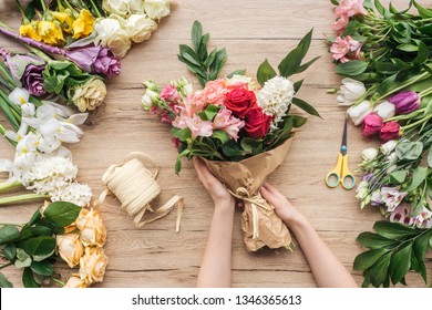 Cropped View Of Florist Making Flower Bouquet On Wooden Surface