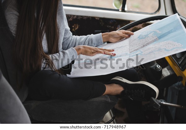 cropped view of\
girl with map sitting in retro styled minivan\
the map was printed\
from\
http://maps.nypl.org/warper/