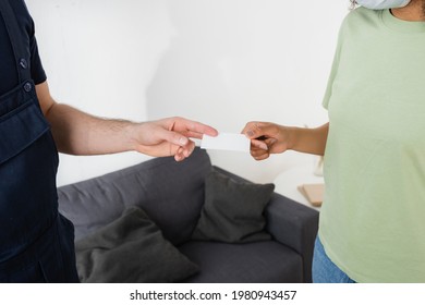 cropped view of handyman giving blank card to african american woman in medical mask - Shutterstock ID 1980943457