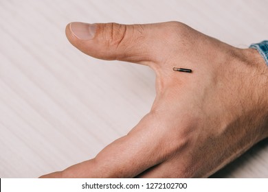 Cropped View Of Male Hand With Microchip On Table