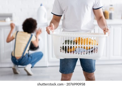 Cropped View Of Man Holding Basket With Dirty Laundry Near African American Woman