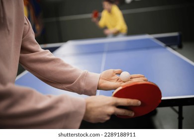 Cropped view of man holding racket and ball while playing table tennis in gaming club