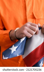 Cropped View Of Man In Jail Uniform And Handcuffs Tearing American Flag, Justice Concept