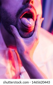 Cropped View Of Man With LSD On Tongue And Woman Touching His Face 