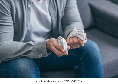 Cropped View Of Man Sitting On Couch And Holding Baby Socks At Home, Grieving Disorder Concept