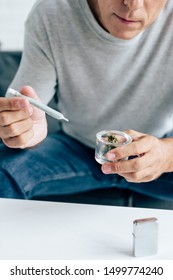 Cropped View Of Man In T-shirt Holding Blunt And Medical Marijuana Buds