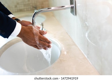 Cropped View Of Man Washing Hands In Public Bathroom 