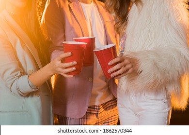 cropped view of man and women toasting plastic cups during party on black - Powered by Shutterstock